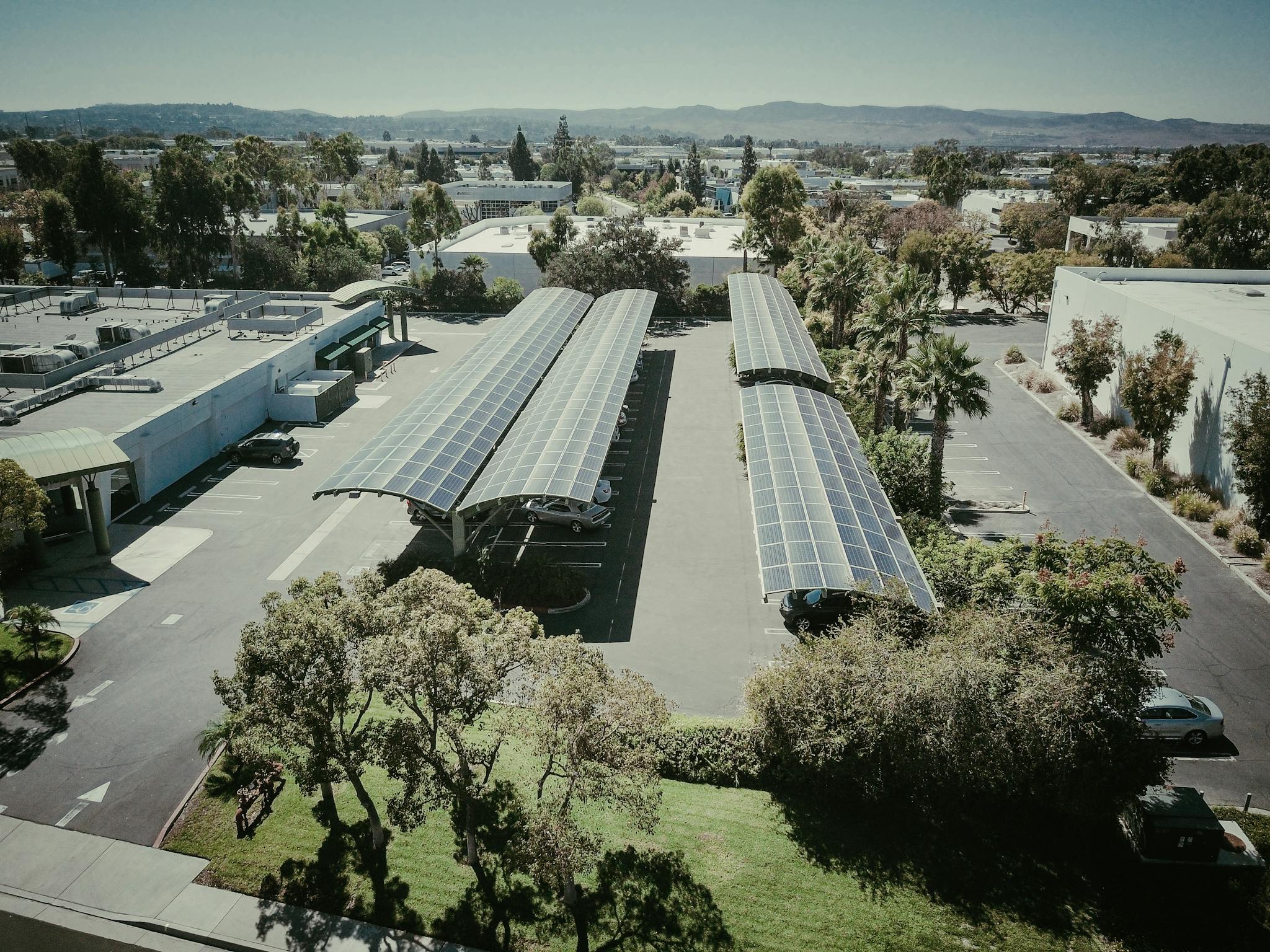Aerial shot of solar panel installations in a suburban neighborhood under clear skies.