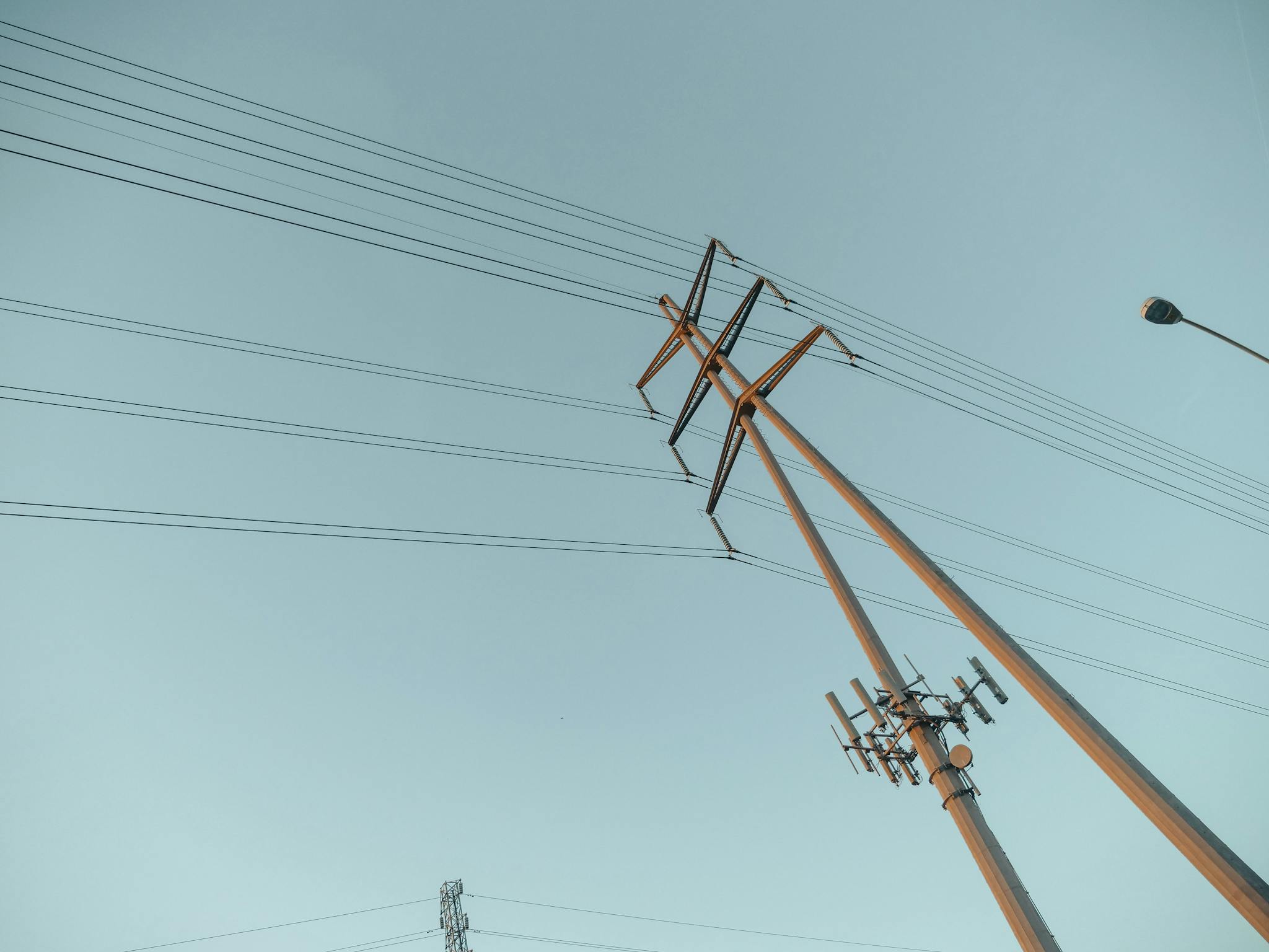 A captivating view of power lines stretching into the clear sky during sunrise, symbolizing energy and connectivity.